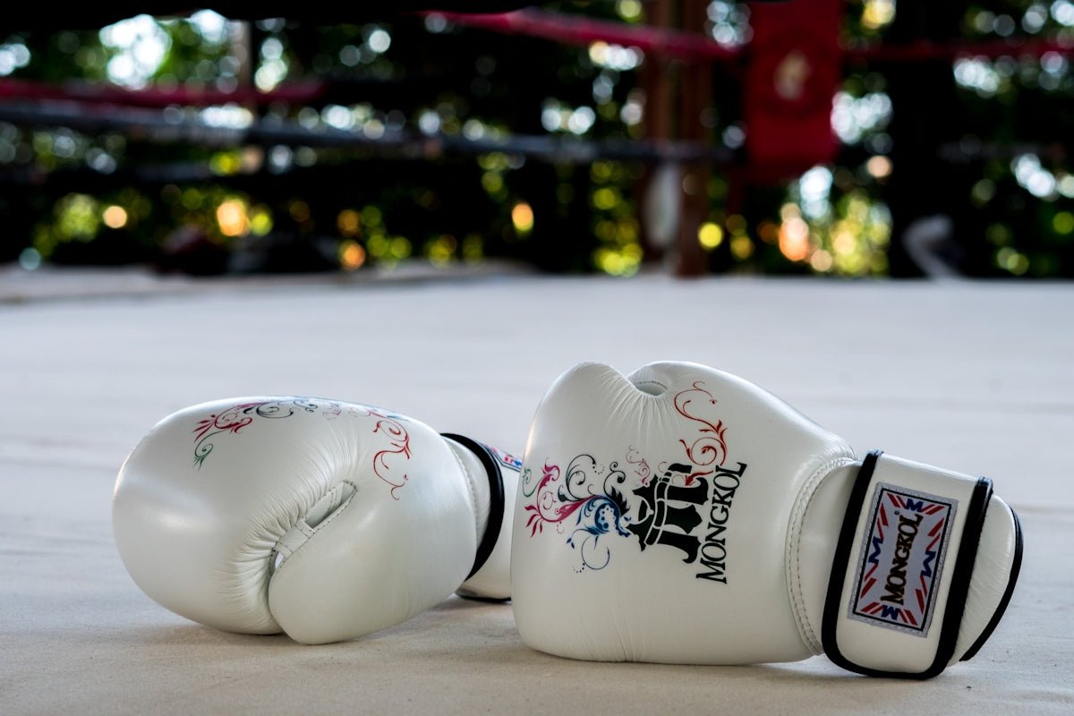 A pair of white boxing gloves laying on the ground